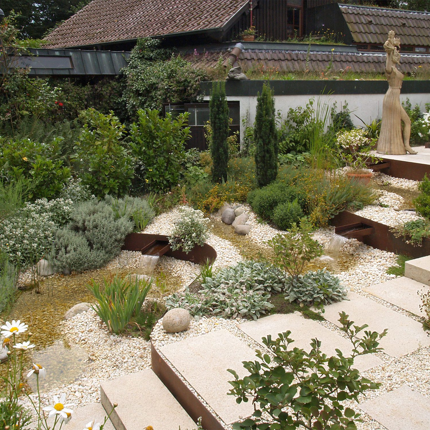 Terrassierungen aus Cortenstahl in einer Gartenanlage mit Bachlauf in der Nähe von Nürtingen