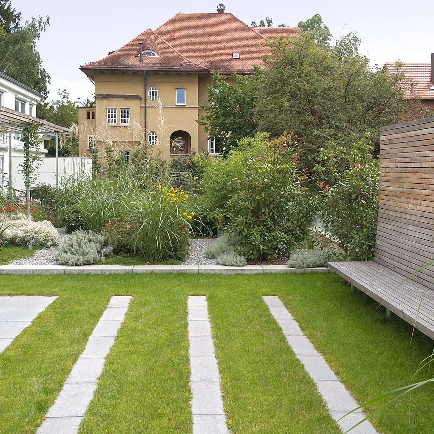 Gartengestaltung mit einer großen Pergola und einem Holzsichtschutz bei Esslingen