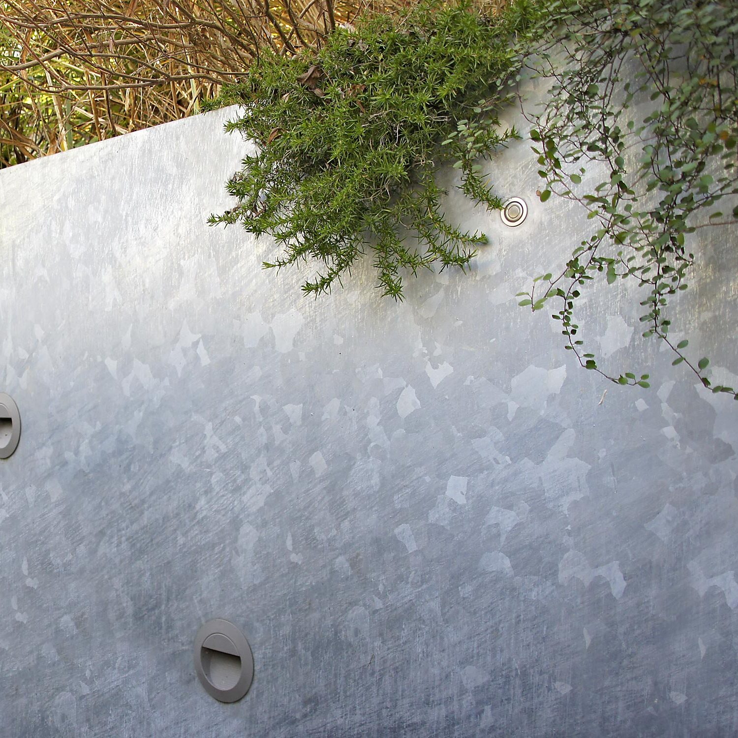 Stahlwand mit eingebauten Leuchten in eienm Reihenhaus-Garten