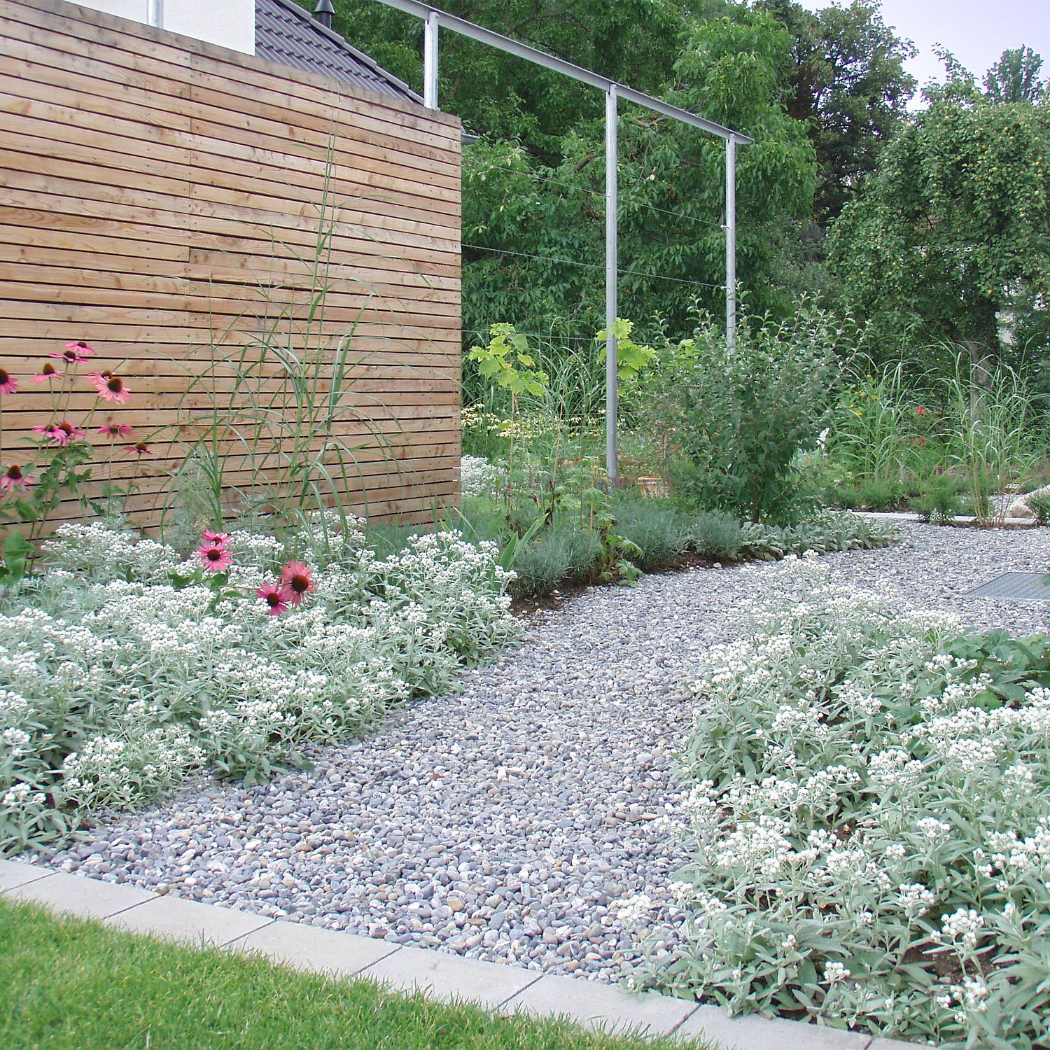 Pergola mit Holzsichtschutz und Staudenbeeten